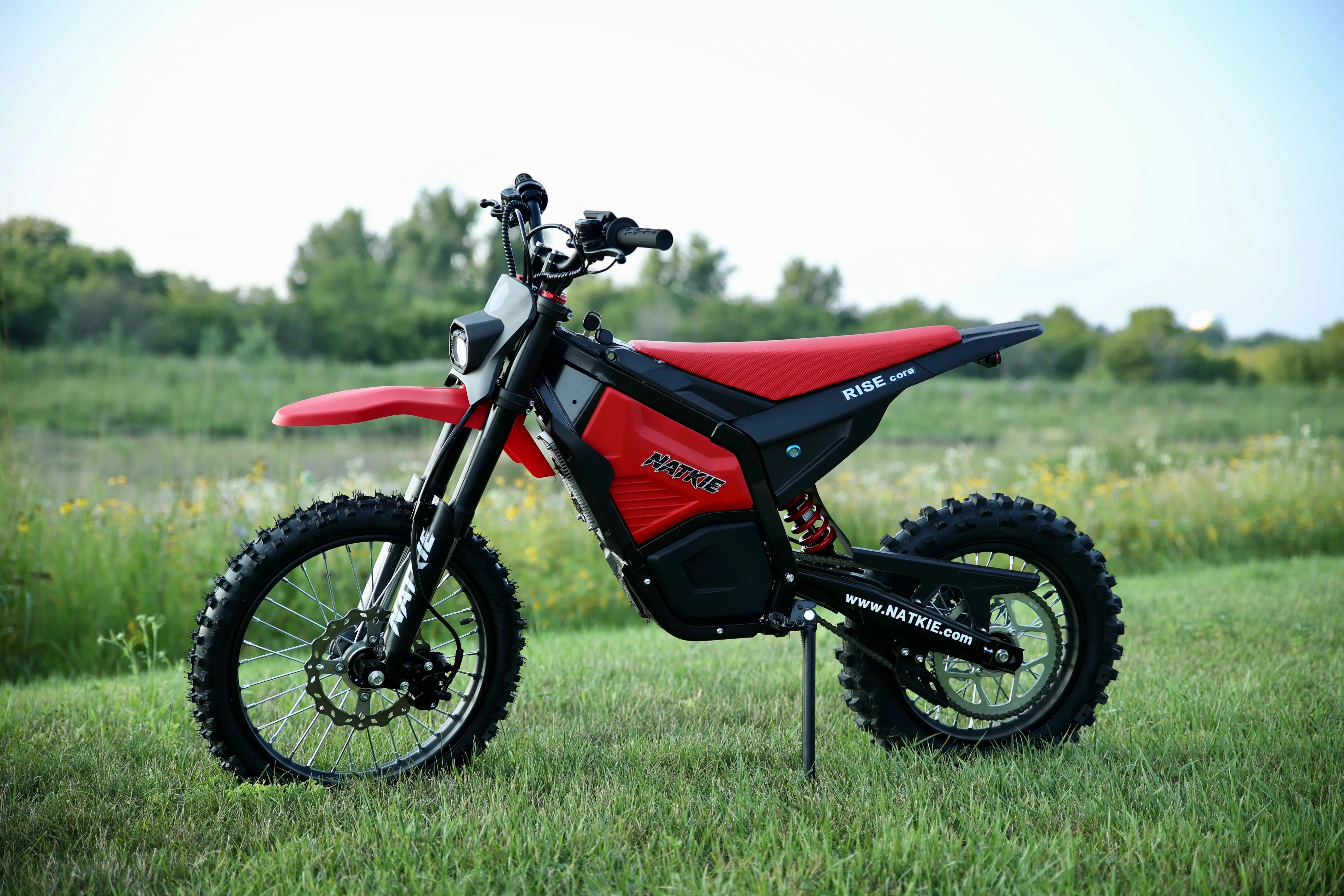 NATKIE RISE Core electric dirt bike standing on a lawn
