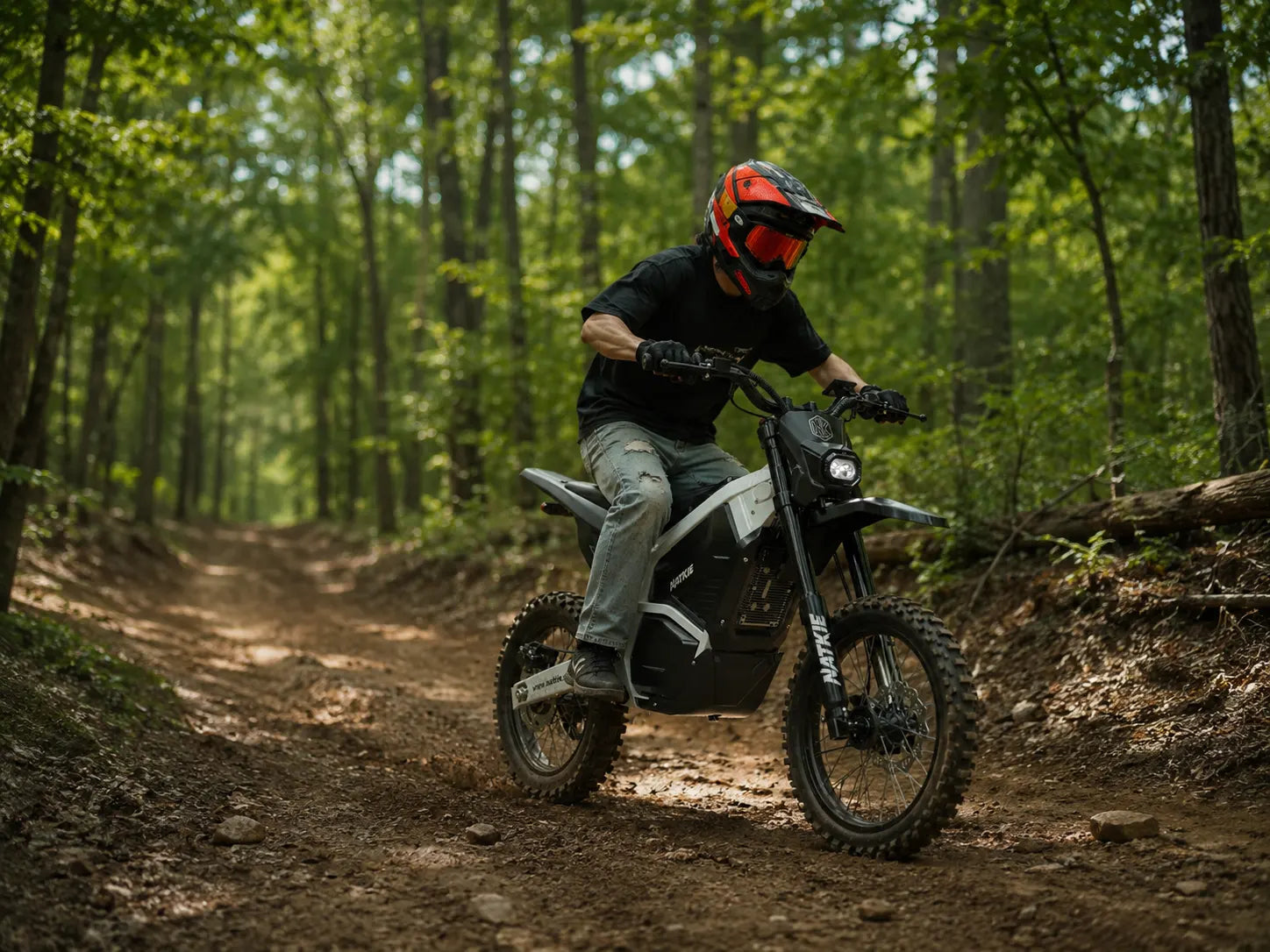 NATKIE electric dirt bike rider on a wooded trail at Red River Motorcycle Trails in Texas